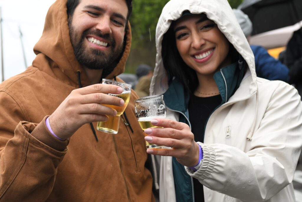 Two people raise their glasses and smile