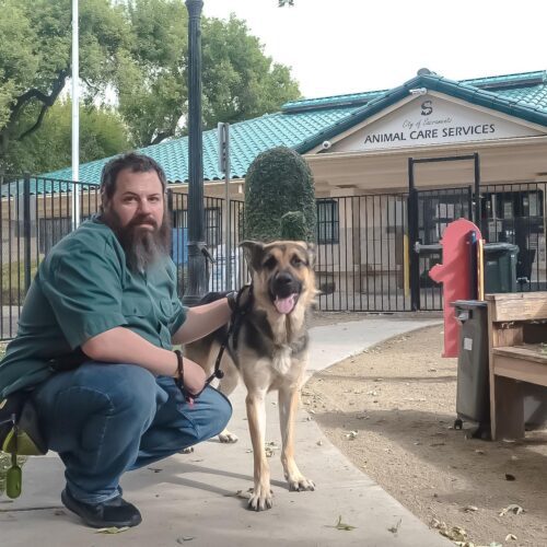 man with dog in front of shelter